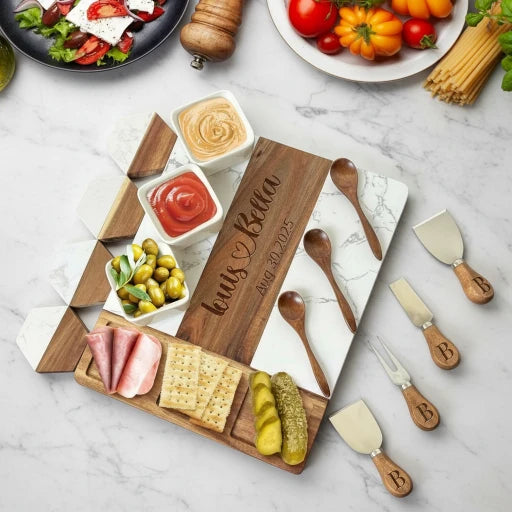 Wooden charcuterie board with various food items and cheese tools on a marble surface.