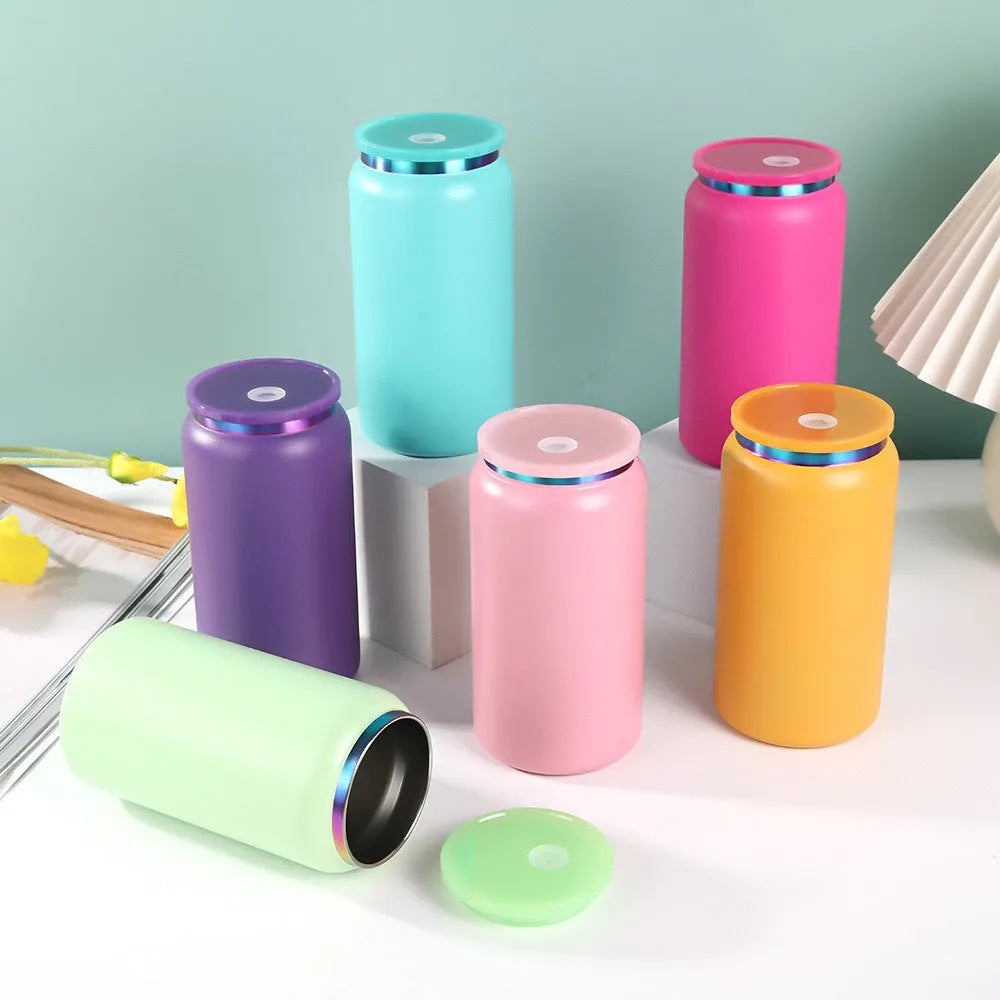 Set of colorful cylindrical containers with lids on a light surface.