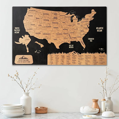 Map of the United States on a black background with cork texture, displayed on a wall above a table.