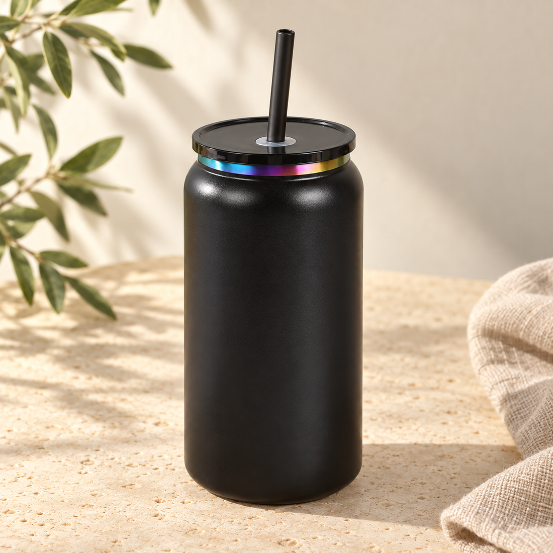 Black 16oz can tumbler with straw on warm cream stone
