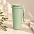 Sage green 24oz travel mug with strap on warm cream stone