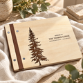 Wooden Airbnb welcome book on warm cream linen, showing engraved cover and binding