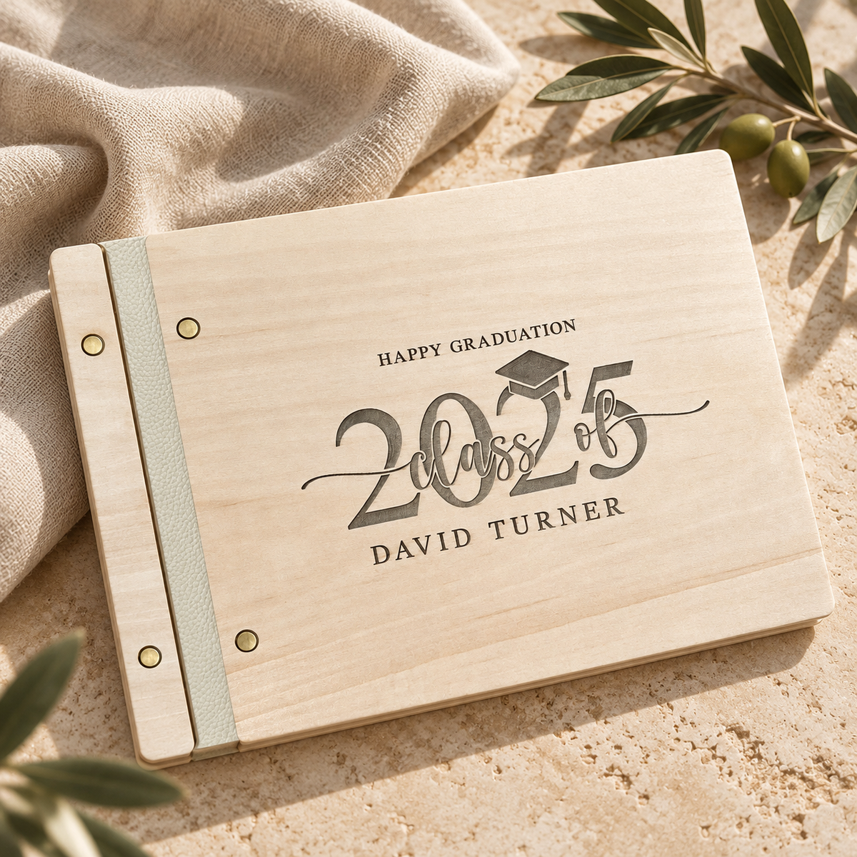 Engraved Class of 2025 graduation guest book on warm stone with natural light