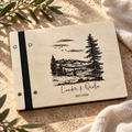 Personalized travel scrapbook with mountain engraving and black binding on a warm stone surface