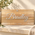 Family name wooden sign on warm stone