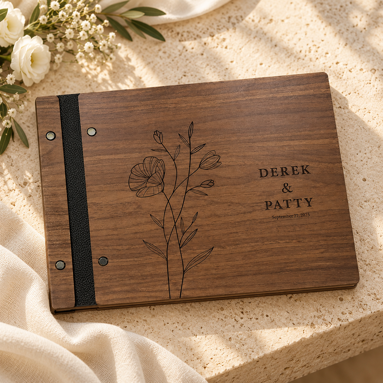 Dark walnut wedding guest book with floral engraving on warm stone
