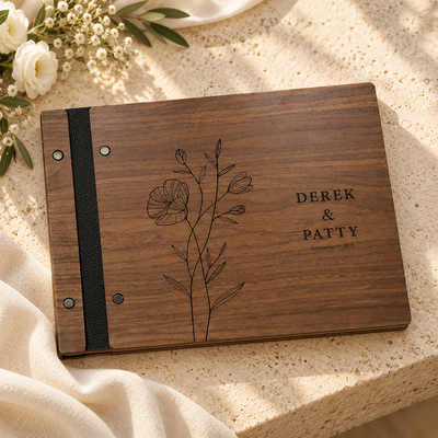 Dark walnut wedding guest book with floral engraving on warm stone
