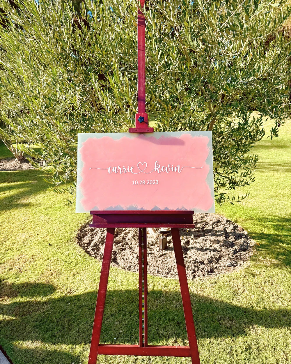 Pink personalized wedding sign on an easel