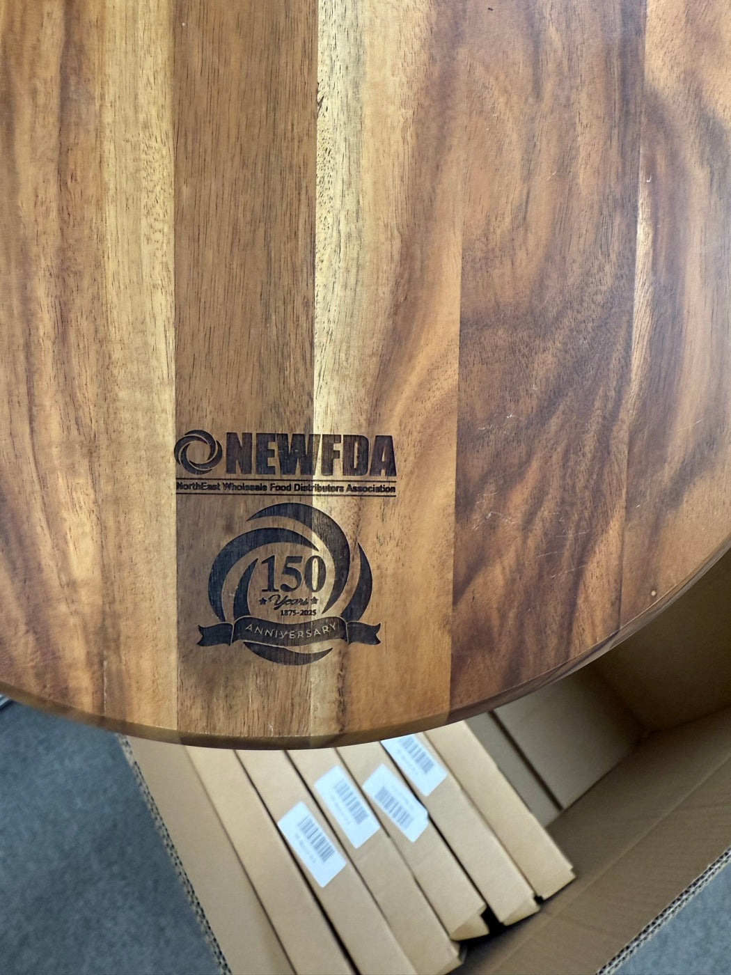 Wooden board engraved with the NEWFDA 150th anniversary logo