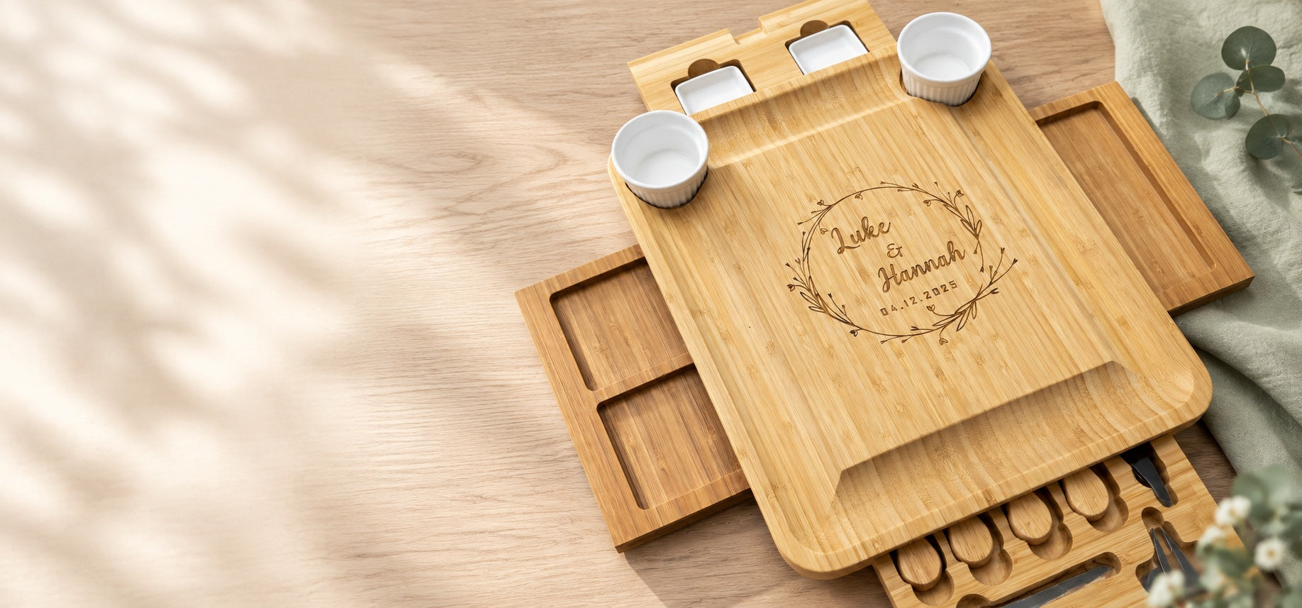 Personalized bamboo serving board with cheese knives in a warm natural setting