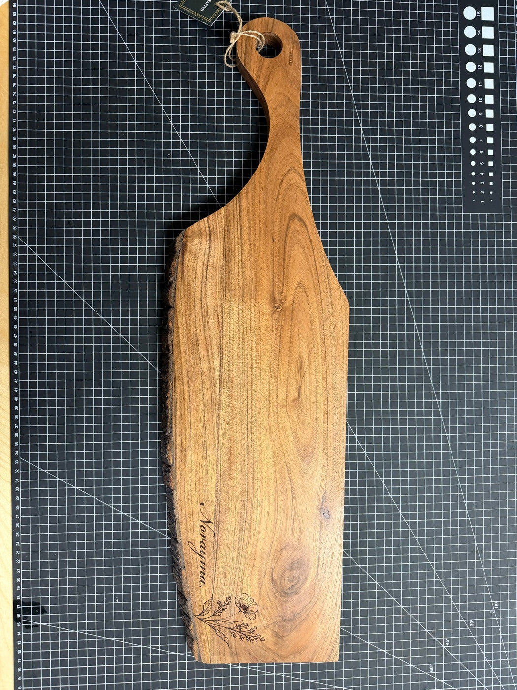 Live-edge wooden serving board with floral engraving